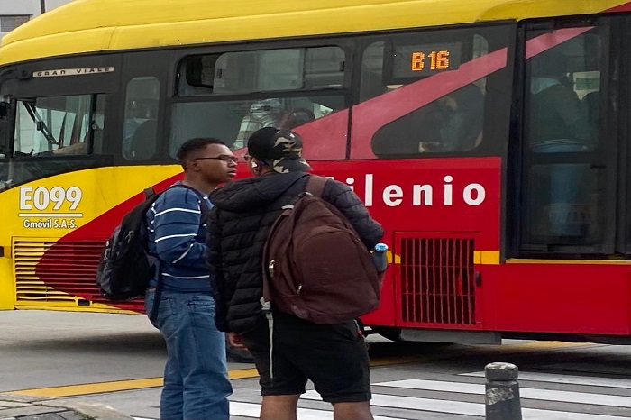 Ciudadanos en paso peatonal de TransMilenio